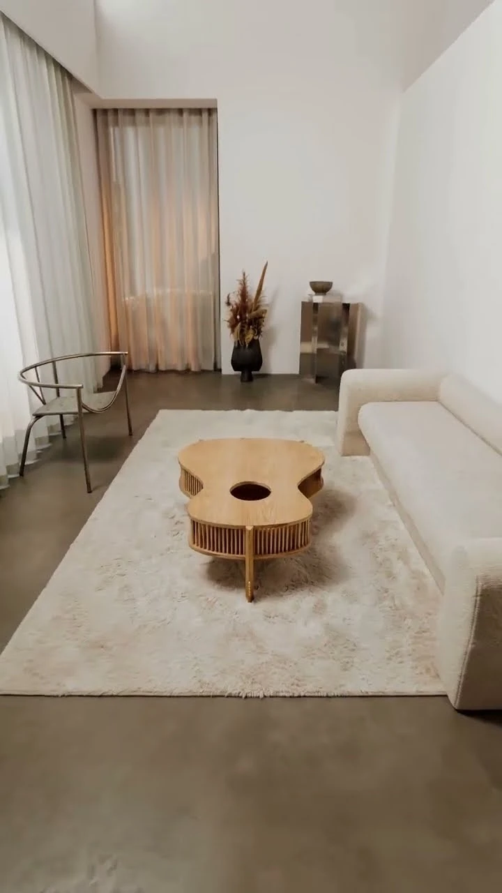 Openhagen guitar-shaped wooden table in a softly lit living room beside a cream sofa