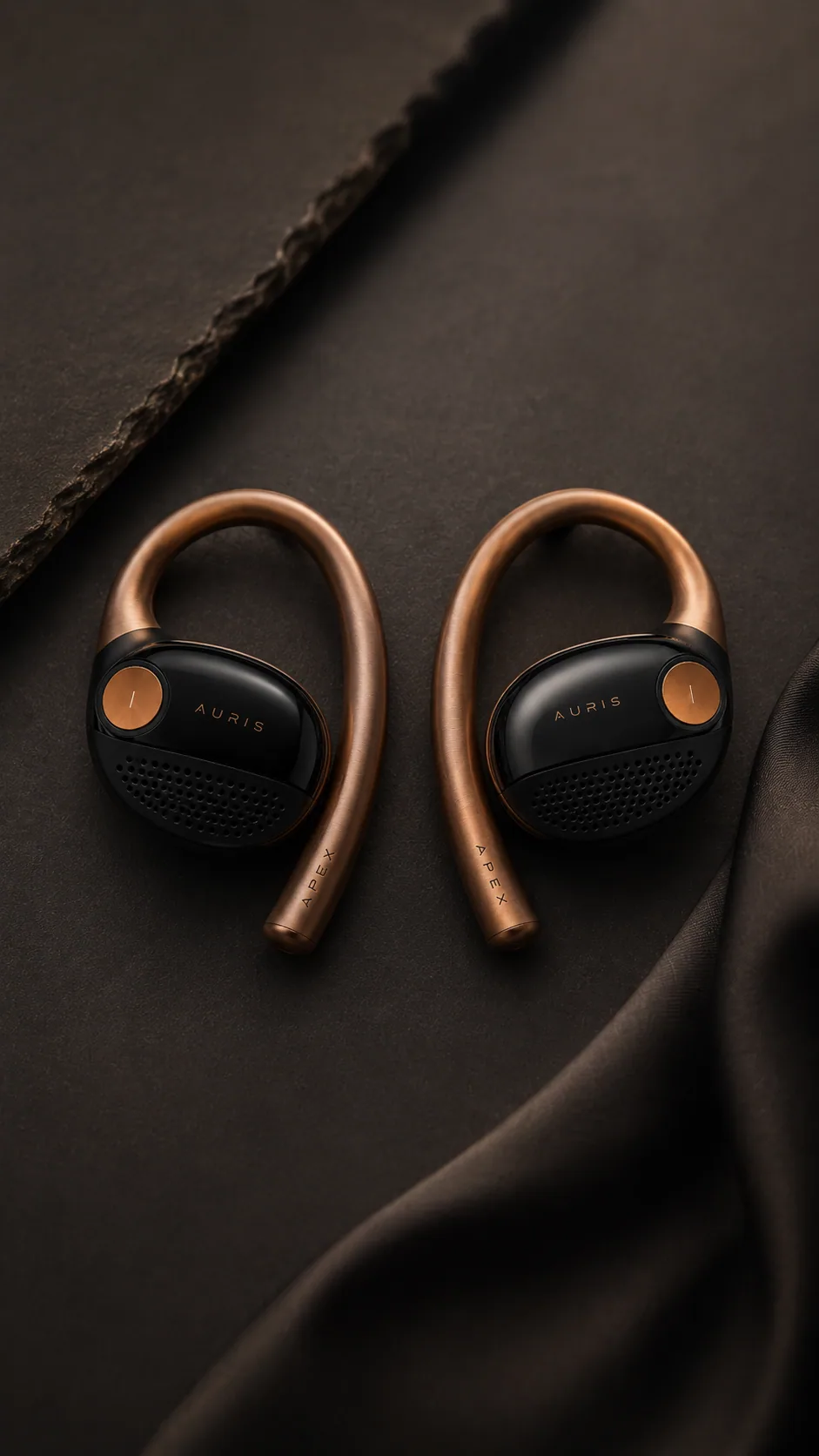 A pair of Auris audio wearables on dark fabric