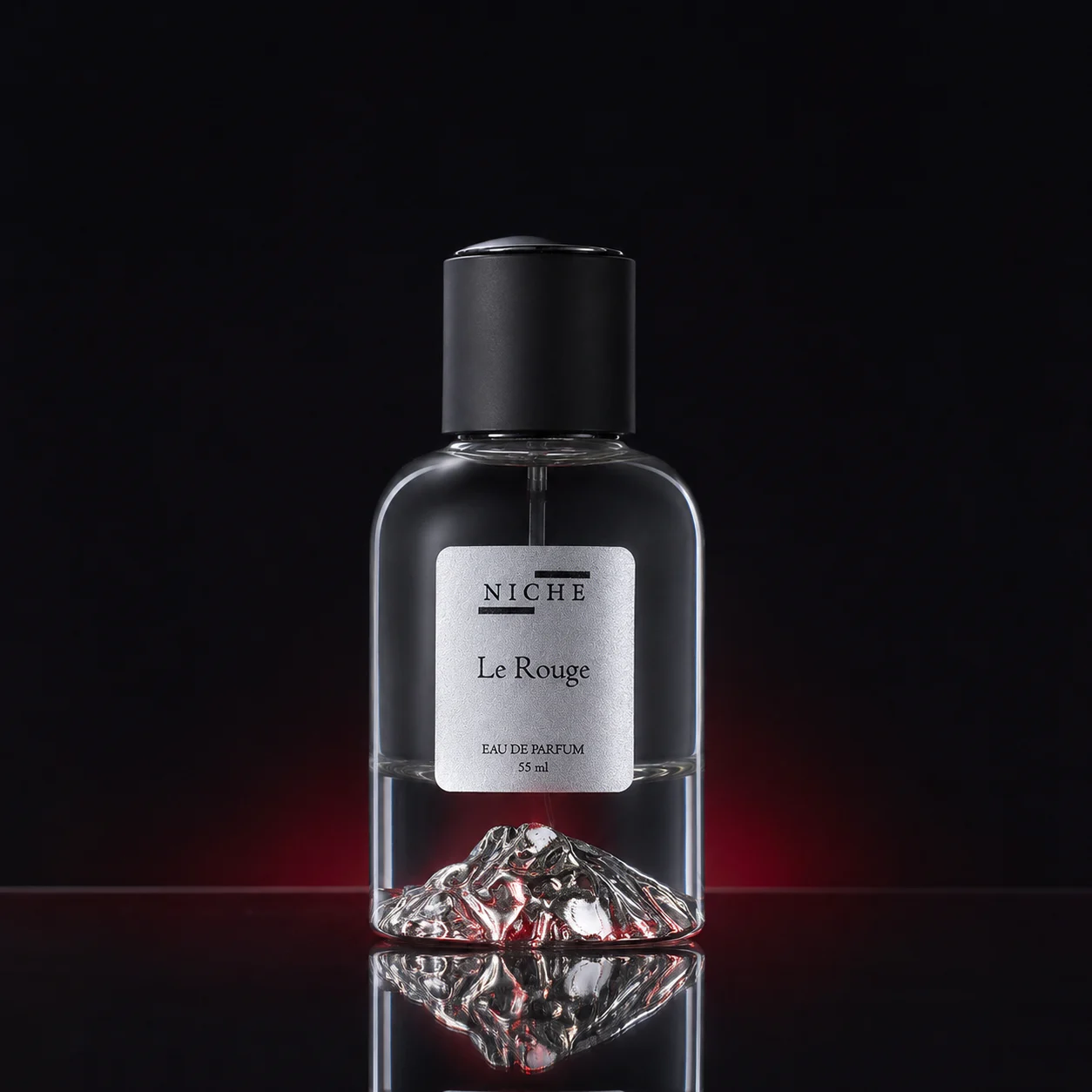 Le Rouge by Niche perfume bottle reflected on a black surface in controlled studio light