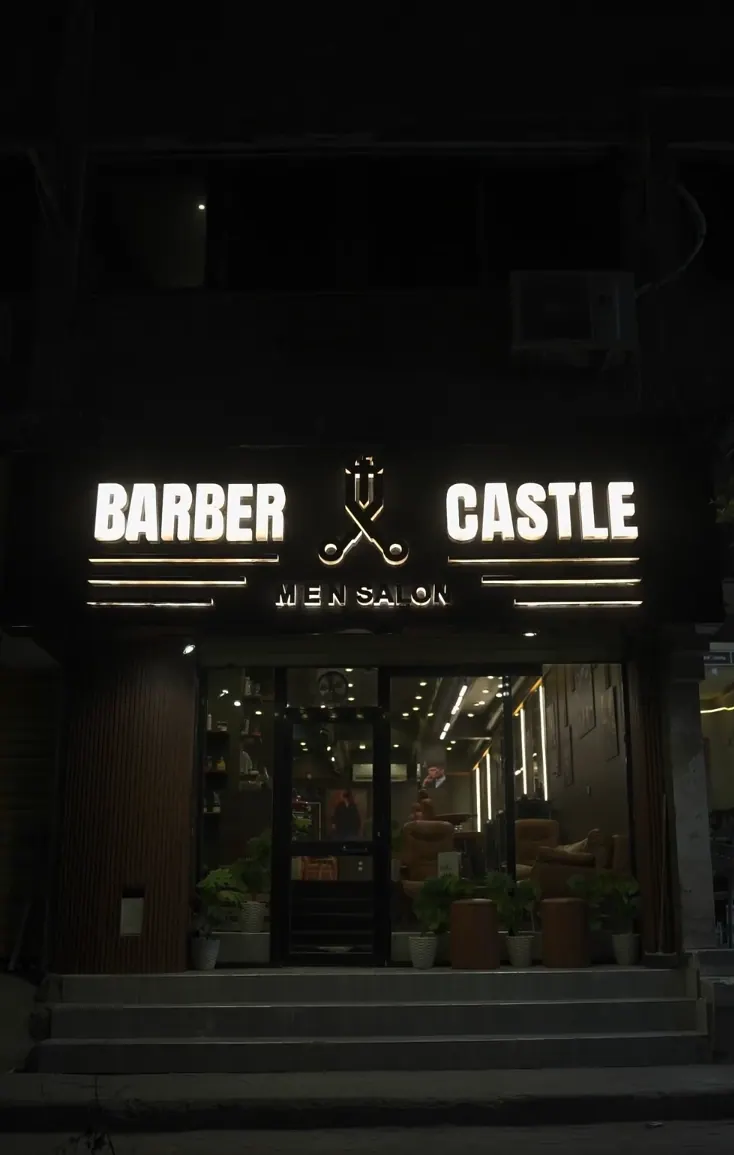 Night source reference of the illuminated Barber Castle storefront