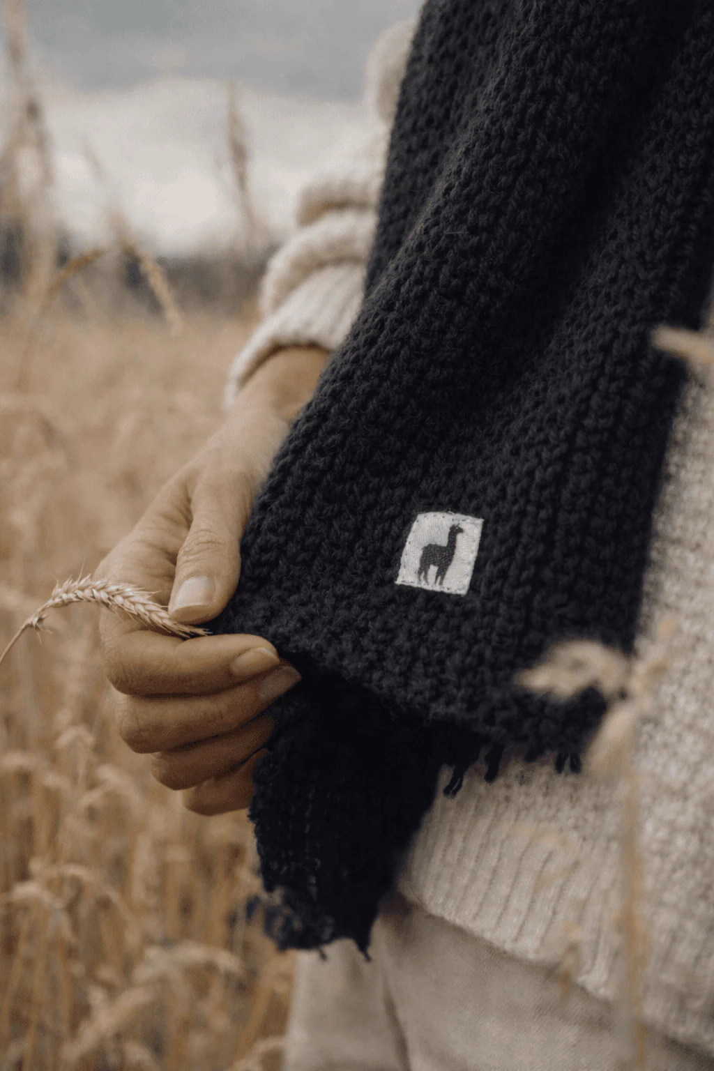 Close-up of the Pokoloko scarf label and textured black knit