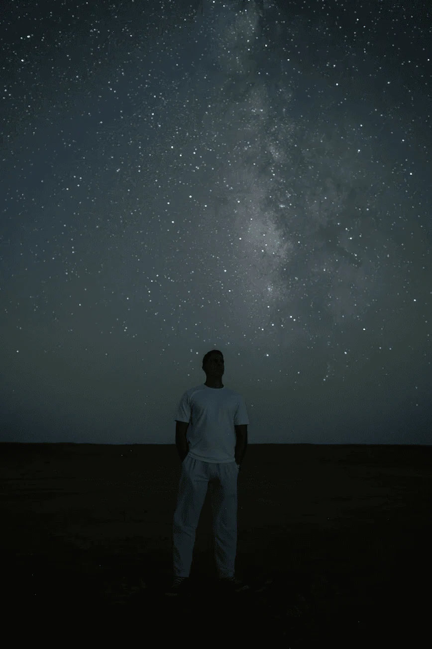 Mohamed Solyman standing beneath the Milky Way in the desert
